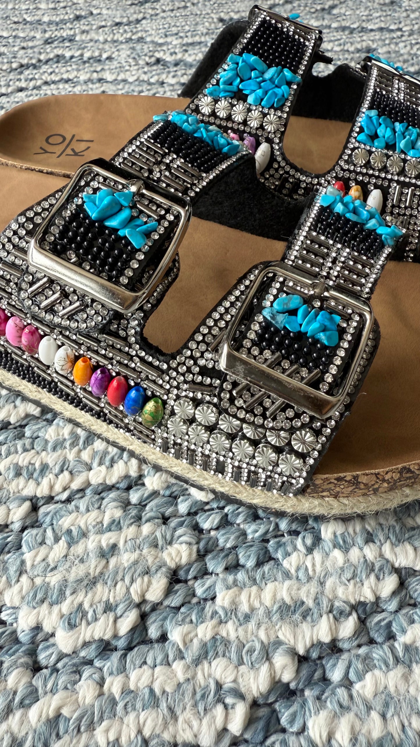 A sandalia negra con Aqua plata
